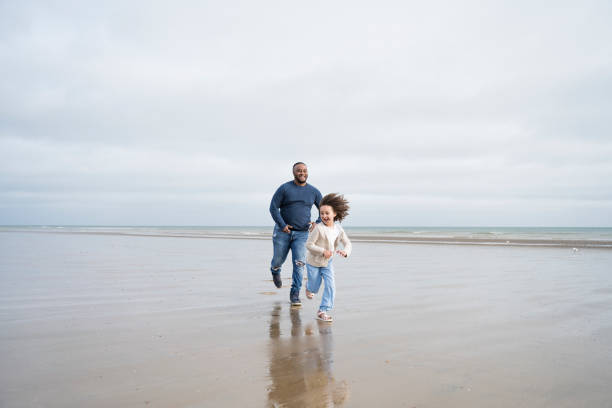istock Father chasing laughing young daughter on beach at low tide 1315157661