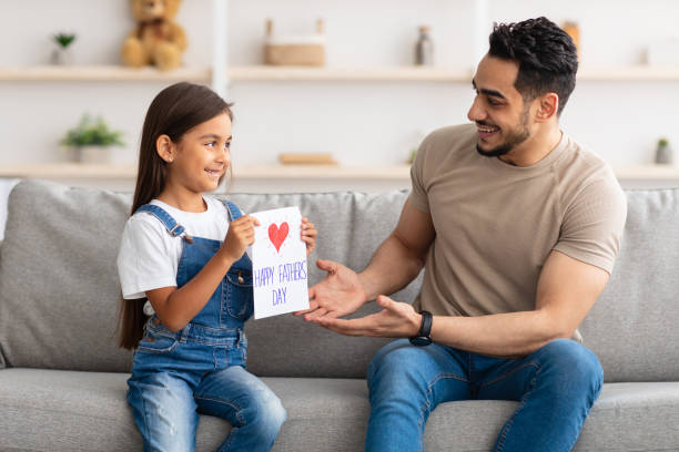 istock Cute daughter greeting young dad with handmade card 1315157890