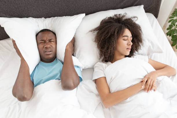 schlaflosigkeit durch schnomeln, störung von schlaf und gesundheitlichen problemen - couple love snoring sleeping stock-fotos und bilder