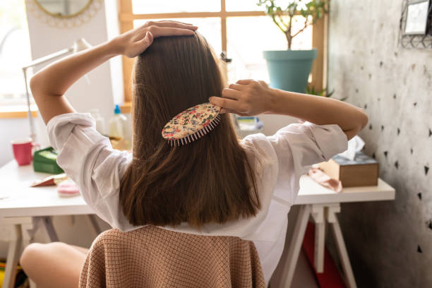 mujer joven con peinar su hermoso cabello castaño - hair care combing women human hair fotografías e imágenes de stock