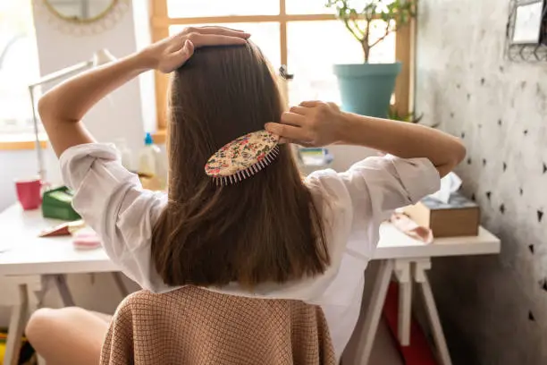 Photo of Young woman with combing her beautiful brown hair