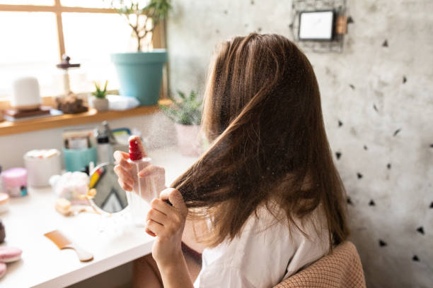 молодая женщина с помощью лака для волос в спальне рано утром - hairspray стоковые фото и изображения