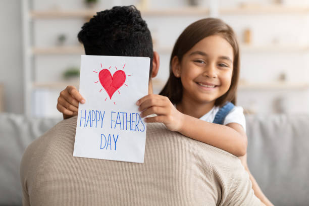 istock Little daughter greeting young dad with card 1315158296