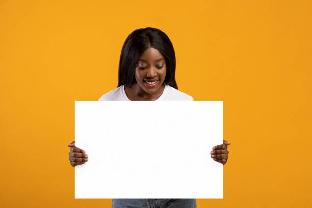 istock Pretty black woman holding blank board for advertisement 1315159108