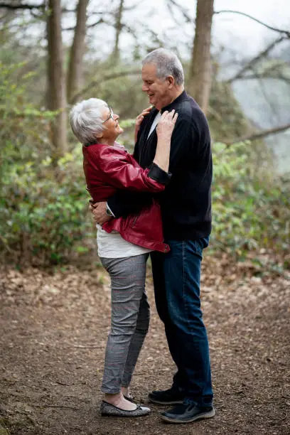Elderly couple standing in nature and holding each other