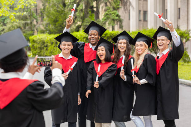 istock Emotional multiracial students having graduation party, taking photos 1315159721