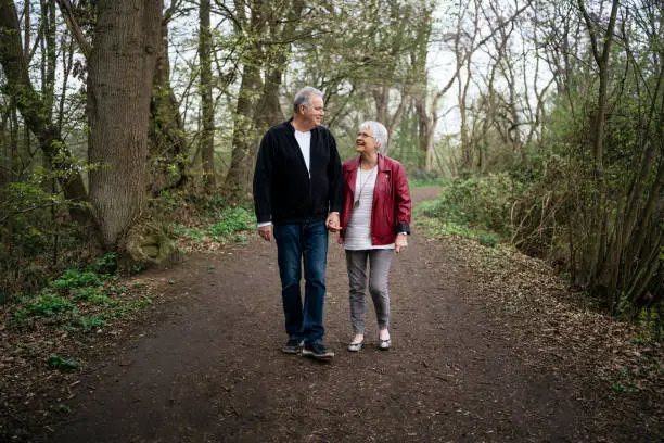 Elderly couple walking in nature and talking lightheartedly