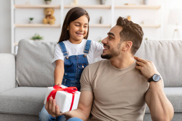 istock Daughter celebrating father's day, greeting excited dad with present 1315163831