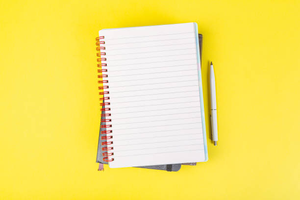 istock open spiral notepad on a yellow background with a pen. top view, stack of notepad with blank sheet. school concept, businessman work desk. 1315167184