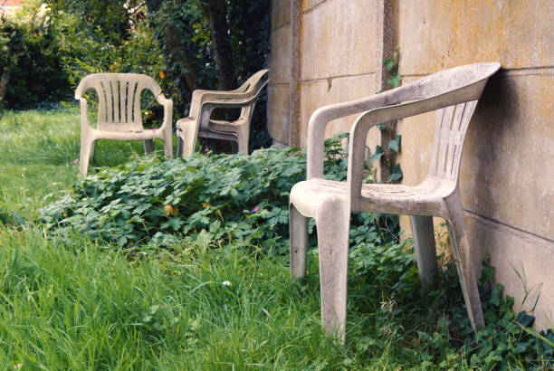 Old and damaged plastic chairs. Empty chairs in a garden. abandoned place photos stock pictures, royalty-free photos & images