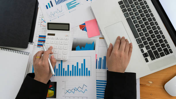 istock Young businessmen analyze data using graphs and laptop calculators in company strategy planning. 1315171854