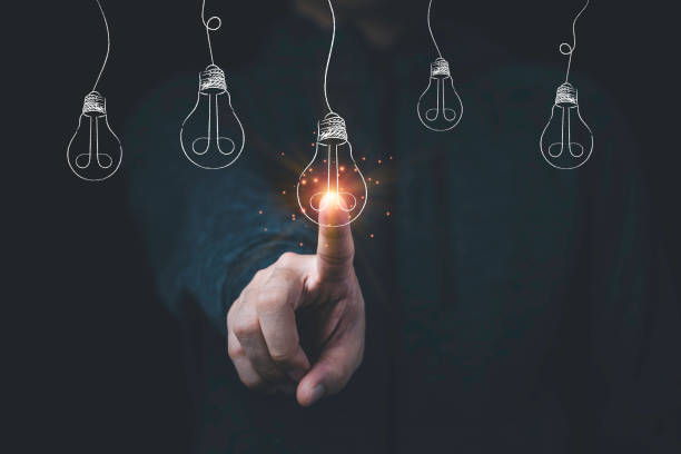 istock Man hand touching to hanging glowing drawing light bulb with orange rays , creative thinking idea and innovation concept. 1315173152