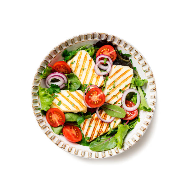 Healthy green salad with grilled halloumi cheese isolated on white background, top view