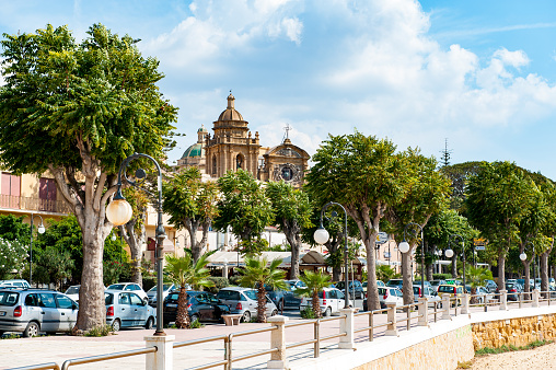 Boulevard with the cathedral of Santissimo Salvatore at Mazara del Vallo. Mazara del Vallo is a town with fishing harbor and a kasbah on the West coast of Sicily.