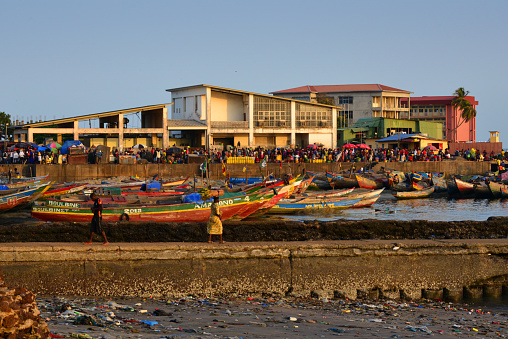 Conakry, Guinea: Boulbinet artisanal fishing port with its traditional pirogues - people on the Los Islands ferries pier - Camp Koundara / Makambo military facilities in the background.
