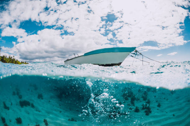 istock Tropical transparent ocean with white boat in Mauritius. Split view with bubbles in water. 1315175564