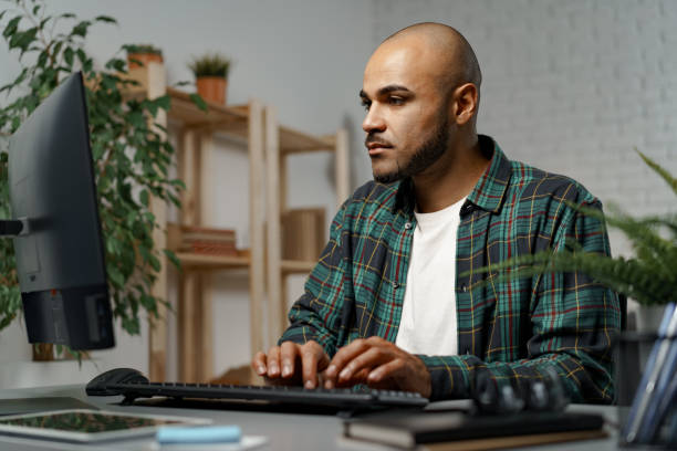 istock African american guy sitting at his working table and looking at computer screen 1315176560