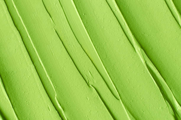 istock Green cosmetic clay (cucumber facial mask, avocado face cream, matcha body wrap) texture close up, selective focus. Abstract background with brush strokes. 1315178791