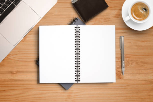 istock Top view of blank notebook memo on working desk among coffee cup and laptop , workplace concept. 1315180721
