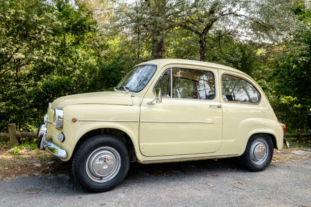 Yellow Seat 600 on a slope in the field. Galicia, June 24, 2020. A very well-kept Seat 600 in the parking lot of a recreational area. The Seat 600 was one of the first cars accessible to the general public in Spain in the 60s. little fiat car stock pictures, royalty-free photos & images