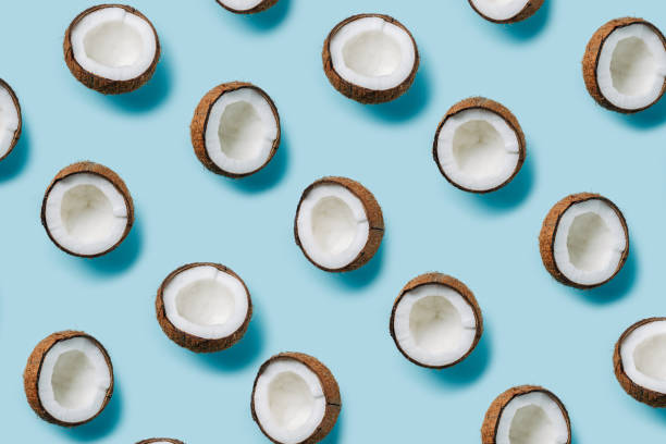 istock Natural texture made with half sliced coconut on pastel blue background. Minimal tropical summer concept. Vegetarian diet layout. Flat lay, top view. 1315189407