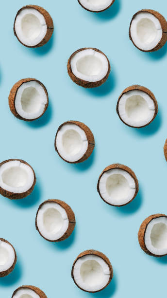 istock Natural texture made with half sliced coconut on pastel blue background. Minimal tropical summer concept. Vegetarian diet layout. Flat lay, top view. 1315189588