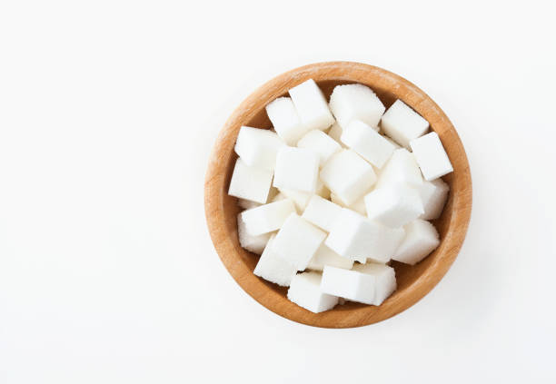 istock White sugar cube in bamboo bowl isolated on white background. Top view. 1315193626
