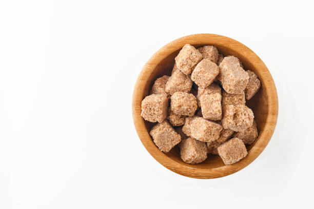 istock Cane sugar cubes in bamboo bowl isolated on white background. Top view. 1315193857