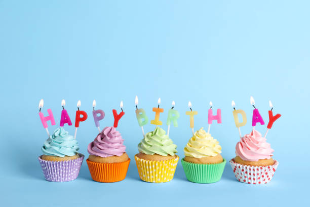 istock Birthday cupcakes with burning candles on light blue background 1315195423