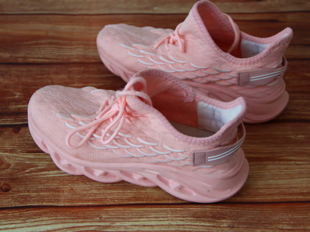 istock Pink womens sneakers on wooden background 1315199074