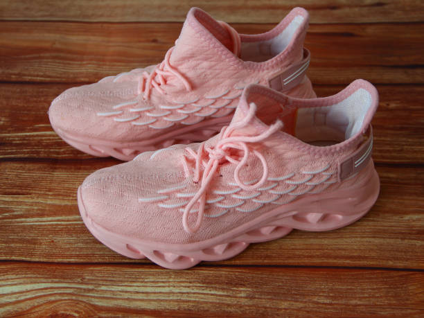 istock Pink womens sneakers on wooden background 1315199103