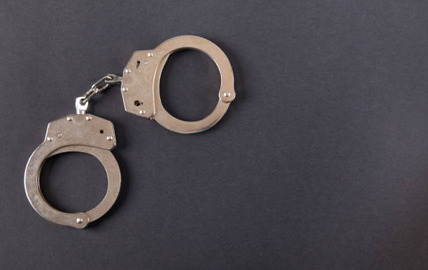 istock Metal handcuffs on an isolated black background. 1315202242