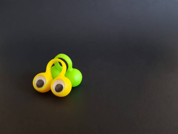 istock Speech therapy toys eyes on fingers on a black isolated background 1315202386