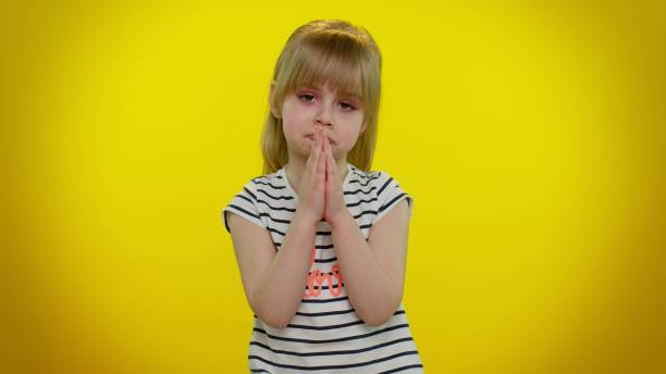 istock Kid child girl praying, making wish, asking with hopeful imploring expression, begging apology 1315203390