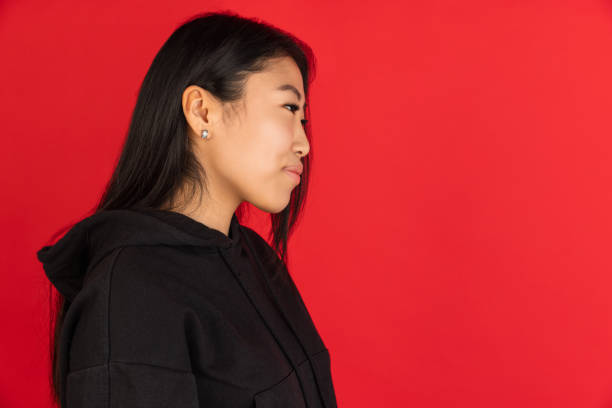 istock Asian young girl's portrait isolated on red studio background. 1315204834