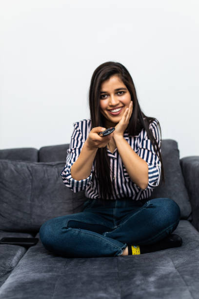 istock young woman in her sofa activating a remote control TV 1315204840