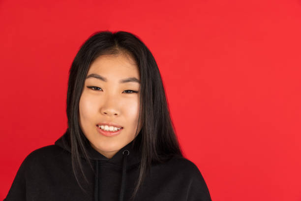 istock Asian young woman's portrait isolated on red studio background. 1315204882