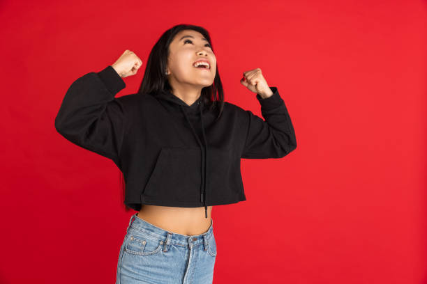 istock Asian young woman's portrait isolated on red studio background. 1315205001