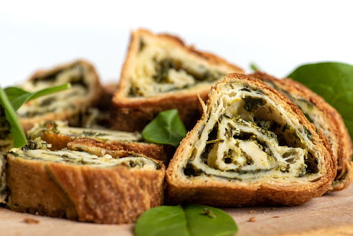 Homemade spinach and cheese triangle pie slices on a table closeup