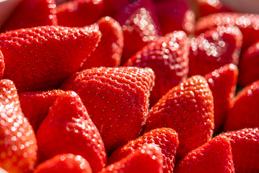 Very close up on natural and organic plenty strawberries. Vibrant red colorful. Fresh fruit background with shallow depth of field