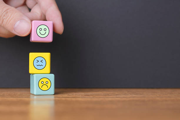 istock Satisfaction survey concept. Hand choose a smiley face on wood block. 1315206936