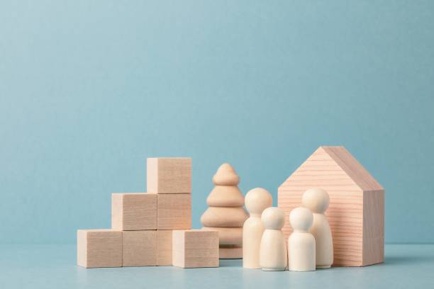Family development and real estate concept. Wooden house and family, wooden cubes stacking as increasing graph bar. stock photo