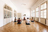 Group of people doing yoga in a bright yoga studio