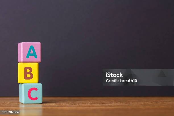Learn Concept Abc Letters Alphabet On Three Toy Blocks In Pillar Form On Wooden Table Stock Photo - Download Image Now