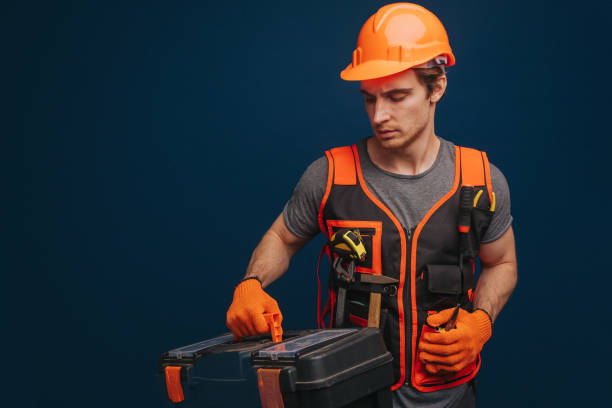 istock Serious young builder is holding equipments, isolated on blue background. 1315208713