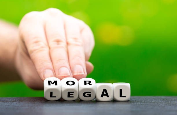 Hand turns dice and changes the word "legal" to "moral". stock photo