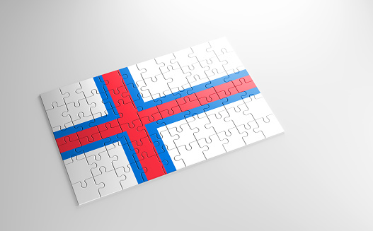 A jigsaw puzzle with a print of the flag of Faroe Islands, pieces of the puzzle isolated on white background. Fulfillment and perfection concept. Symbol of national integrity. 3D illustration.