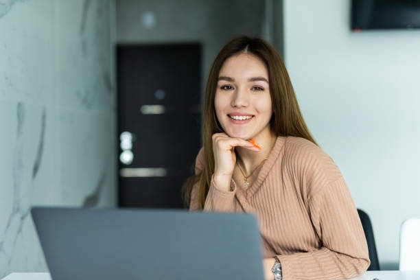istock Pretty young woman working with laptop and documents in the kitchen at home. 1315216356