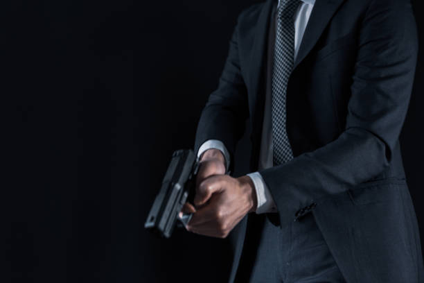 istock Man in a suits and holding modern semi-automatic pistol 1315218013