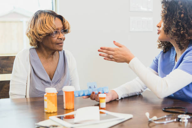istock Nurse gestures while assisting senior patient with organizing pill box 1315220297